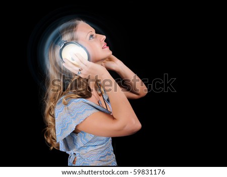 The girl in headphones listens to music. Black background