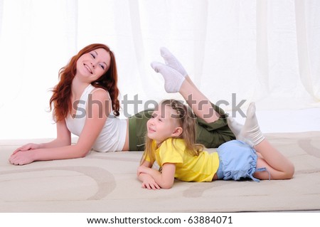 Young mother with her daughter doing sport exercises