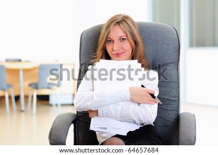 A young girl in his office sits in a gray chair.