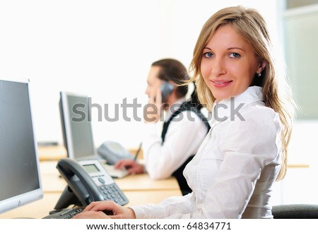 A young girl in his office at his workplace works at the computer