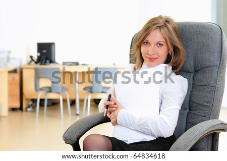 A young girl in his office sits in a gray chair.