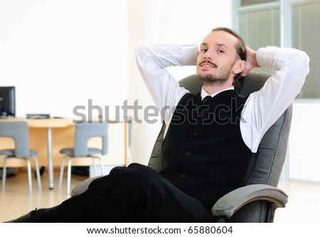 A business man in his office rests in the chair.
