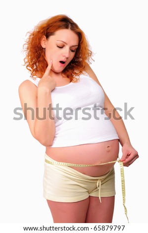 stock photo Young pregnant mom measure her belly on white background