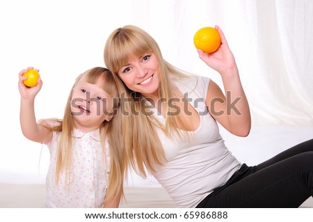 Young mother and child spend time together. kept in the hands of oranges
