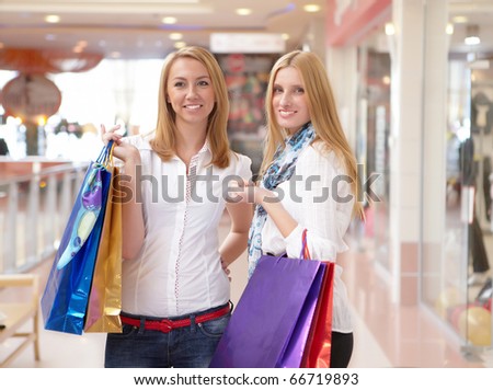 Two young beautiful girls are engaged in shopping in a store