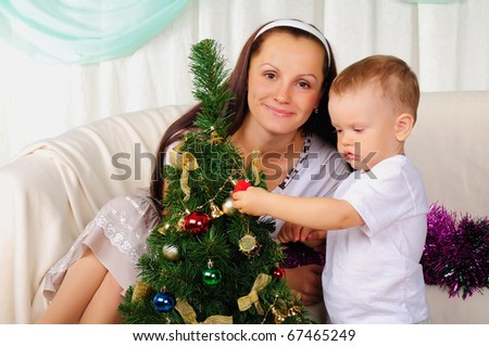 Young mother and her son are preparing for the holiday together. Happy New Year!