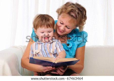 Grandmother and grandson reading a book together. Symbol of the family.