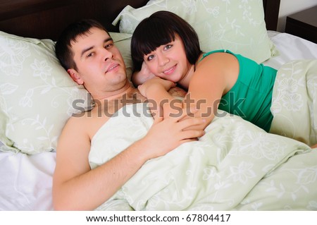 A young couple had just woken up in bed together early in the morning.