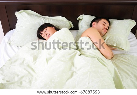 Young couple sleeping together in one bed.