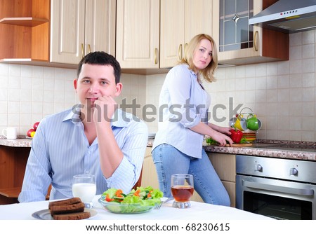 The wife and husband have breakfast together in his kitchen.