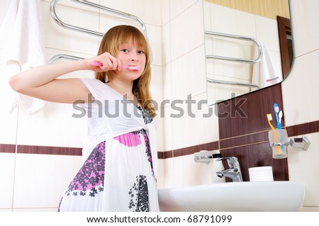 A young girl waking up early in the morning, brushing his teeth in his bathroom