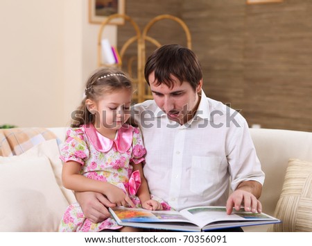 young family with a daughter at home in the living-room