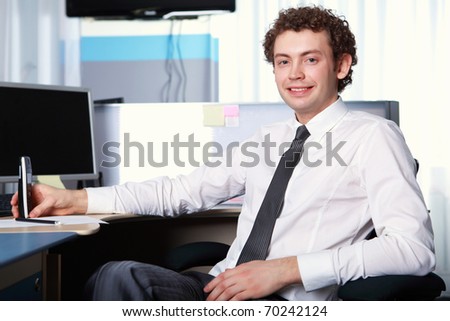 a young smiling businessman in formal wear in office