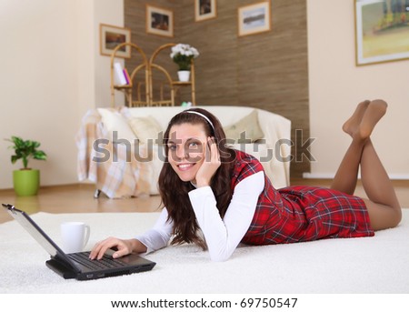 a young girl with a lap top at home on the floor of a living room