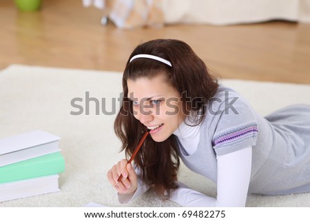 a young female student reading books at home on the floor in the living room