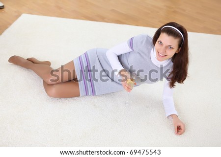 a young girl with a glass of wine or champagne at home on the carpet