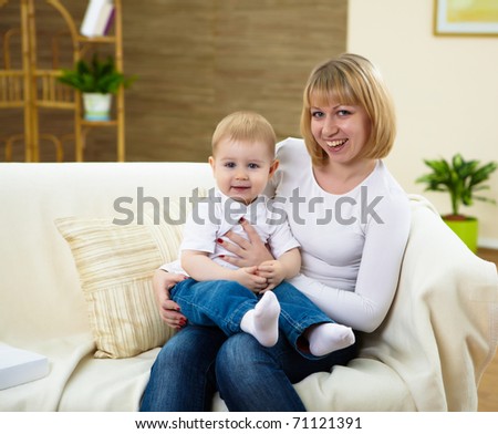 little boy and his young mother together at home sitting on the sofa