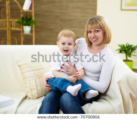 little boy and his young mother together at home sitting on the sofa