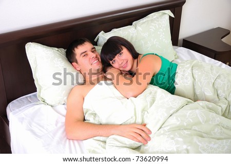 A young couple had just woken up in bed together early in the morning.
