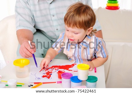 Grandfather and his grandson involved in drawing together. Symbol of the family.