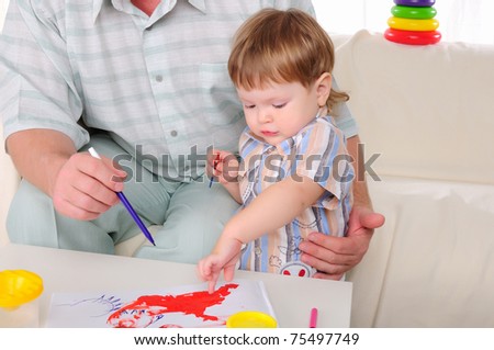 Grandfather and his grandson involved in drawing together. Symbol of the family.