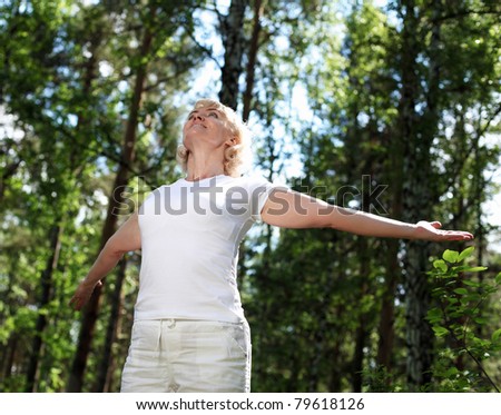 Elderly woman playing sports in the forest.