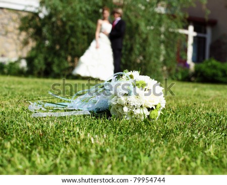 Suite bouquet in the foreground. In the background, the bride and groom. Symbol of marriage.