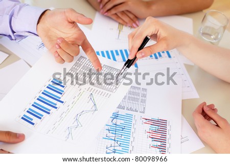 financial and business documents on the table and human hands