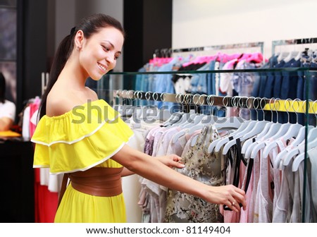Beautiful young girl at the store chooses to purchase clothing