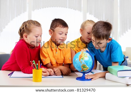 Group of pupils studying a globe together