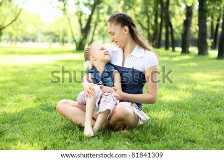 Mother with her daughter outside in the summer park