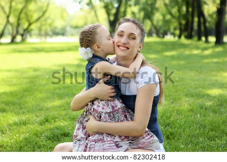 Mother with her daughter outside in the summer park