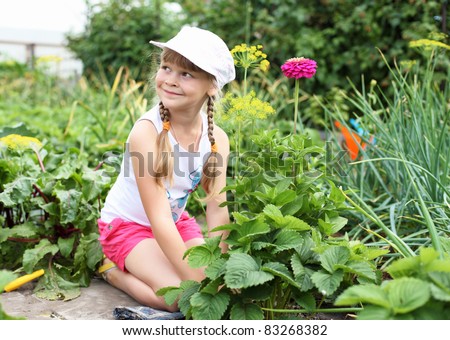 Little happy girl gardening in the summer