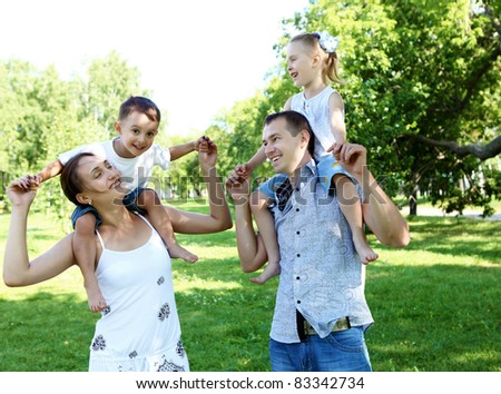 Young happy family with two children in the summer park