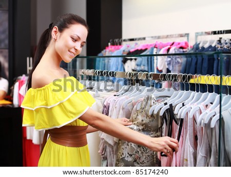 Beautiful young girl at the store chooses to purchase clothing
