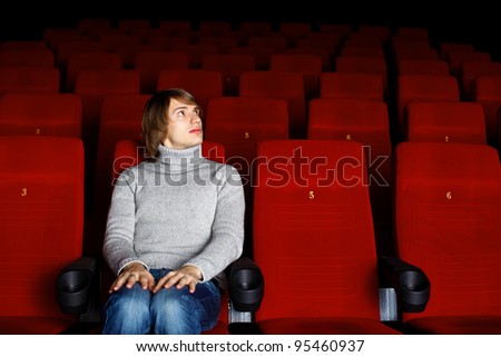 Young man sitting in cinema and watching movie