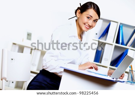 Portrait of young woman in business wear in office