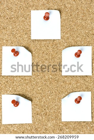 pin board with white papers and red pins