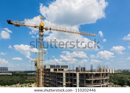 New tall modern building construction with lifting crane