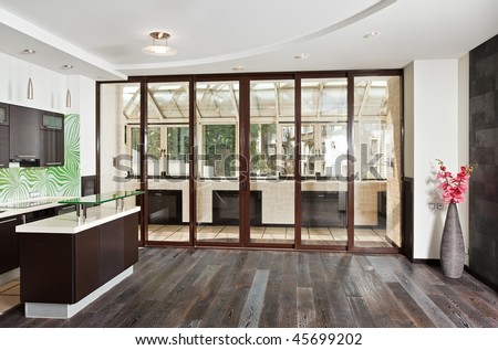 Modern drawing room (studio) and Kitchen interior with balcony and dark wooden floor, front wide angle view
