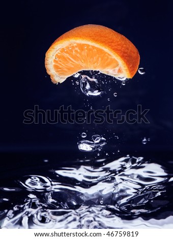 Orange (mandarin) falling in blue water with air bubbles