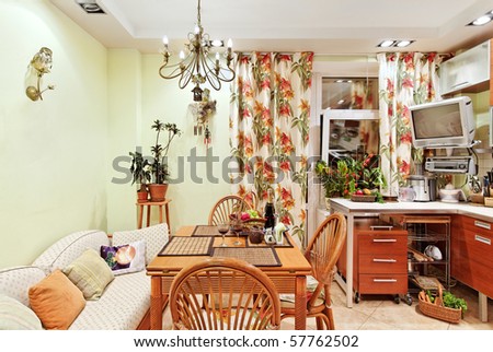 Kitchen interior with wooden furniture, table and many utensils in warm tones on wide angle view