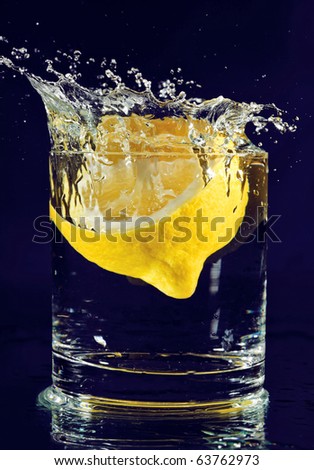 stock-photo-half-of-lemon-falling-down-in-glass-with-water-on-deep-blue-63762973.jpg