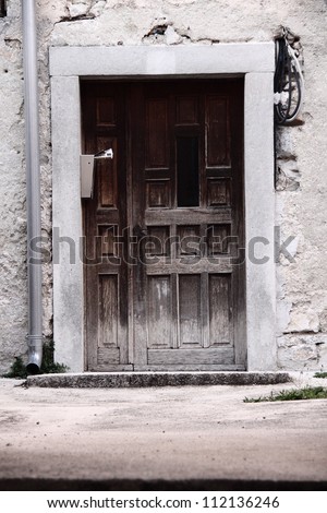 Old dirty wooden door and broken facade with drip installation