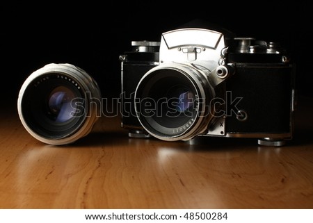 Vintage camera on the wooden table with pair of lens