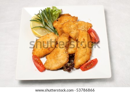 Fried turkey steak with tomatoes and lemon