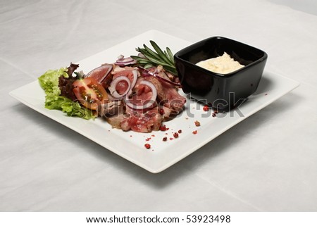 Beef steak with black saucer filled by horseradish