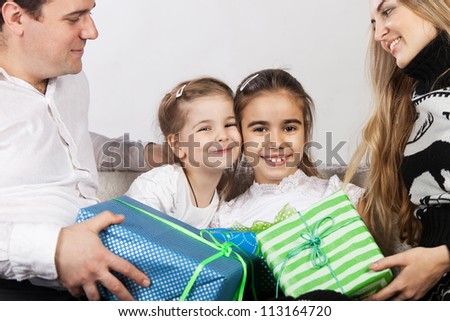 Happy family with presents. Father and mother give presents to they daughters