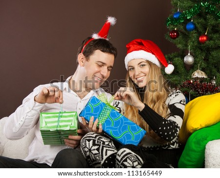 Happy couple in Christmas hats near the Christmas tree