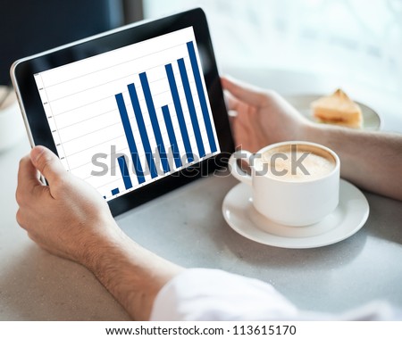 Man holding tablet computer with graphic in cafe